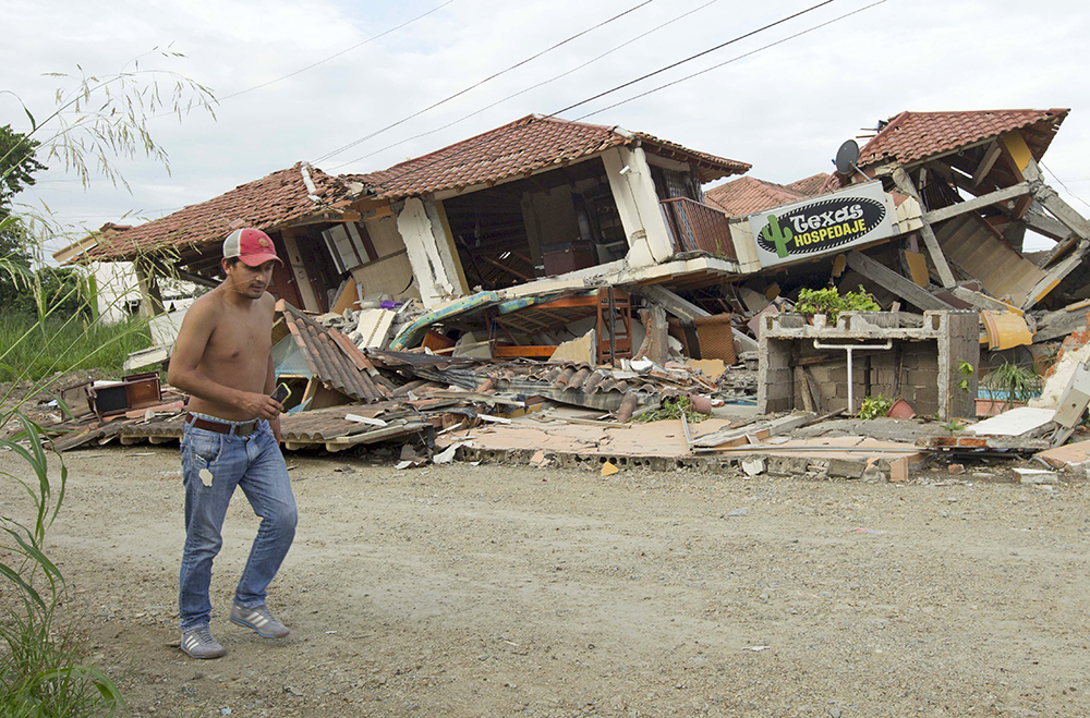 A man walks past a collapsed building in Pedernales Monday, after an earthquake struck off Ecuador's Pacific coast. The 7.8 magnitude quake is the worst the country has experienced since 1979. Reuters