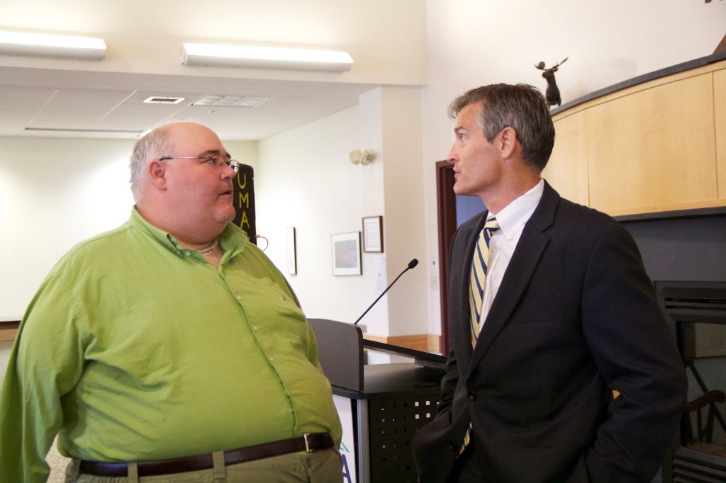Roger Mackbach, left, speaks with former UMA President Glenn Cummings. Mackback was involved in a boating accident that ultimately ended with the loss of his right arm.
