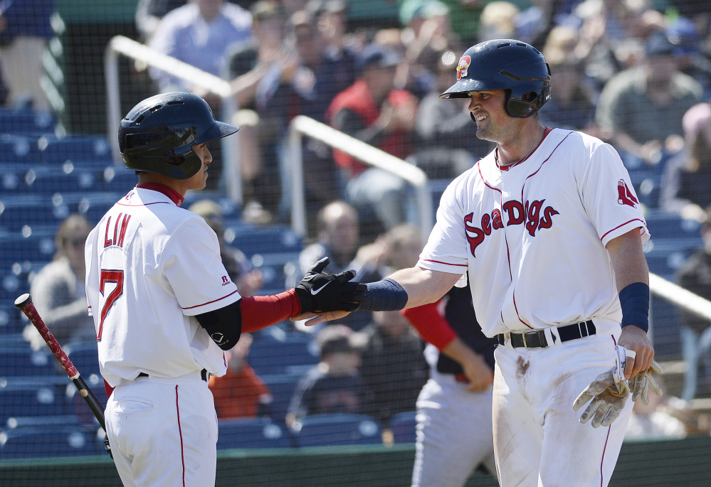 Portland's Jordan Betts, right, is congratulated by teammate Tzu-Wei Lin after Betts scored for the Sea Dogs against the Reading Fightin Phils on Saturday. The Sea Dogs won, 6-3. 