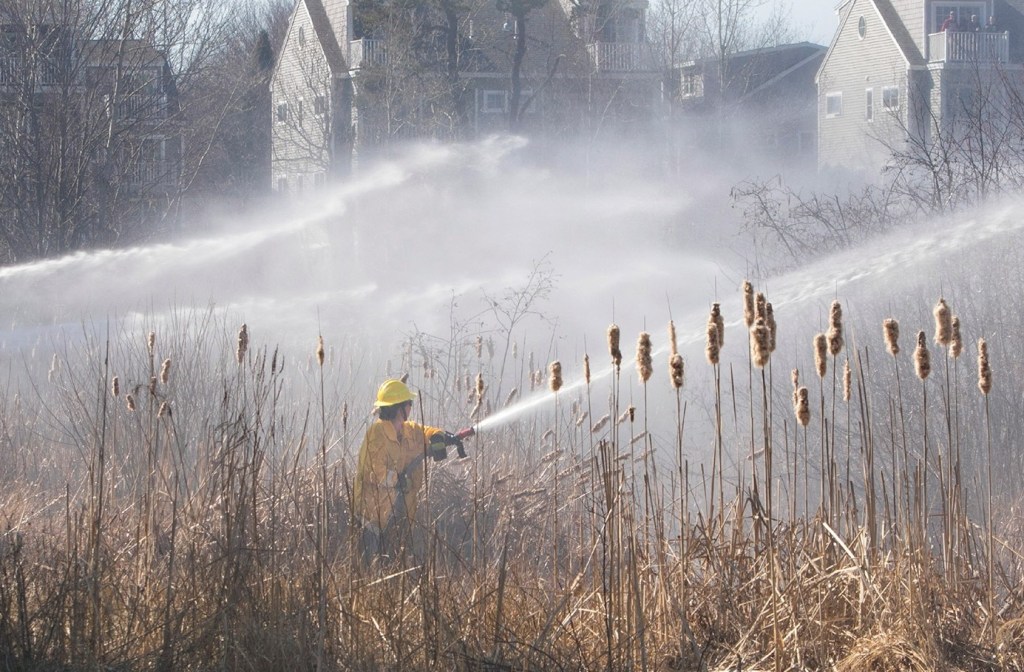 Firefighters battle the four-alarm brush fire that Ricky Plummer is charged with setting in April in Old Orchard Beach.