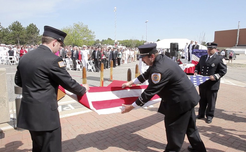 From left, Ian Canavan, Jim Backman and Bill Price, firefighters with the Brunswick Naval Air Station, fold the flag at the base for the last time during a disentablishment ceremony on May 31, 2011. Gregory Rec/Staff Photographer