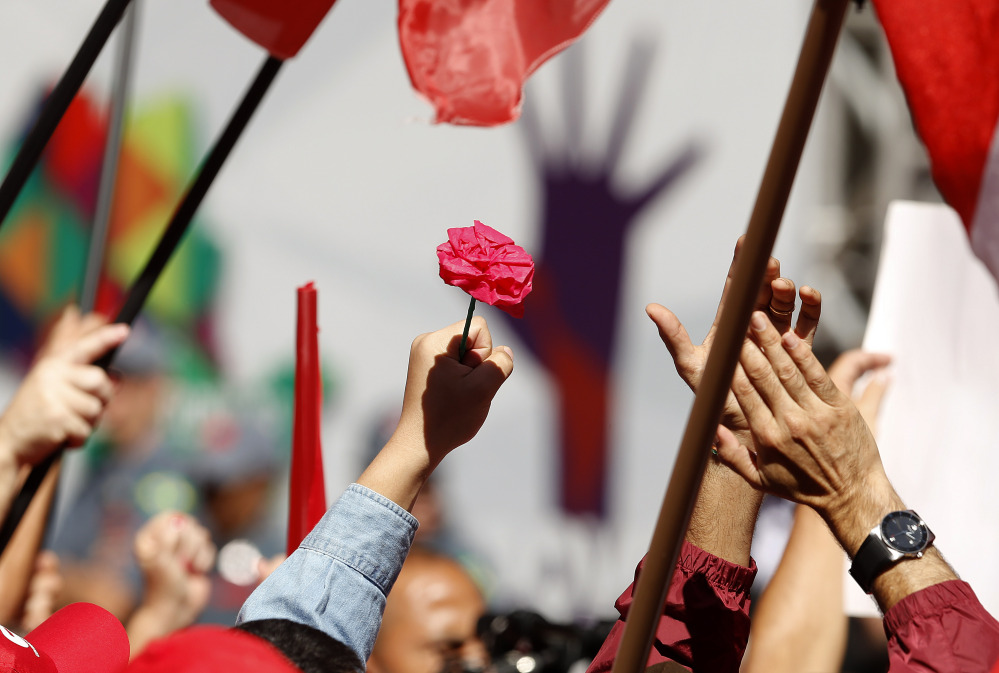 A demonstrator holds a flower during a May Day rally in support of Brazil's President Dilma Rousseff, in Sao Paulo, Brazil, on Sunday.