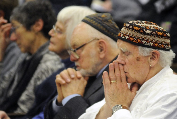 People reflect during the Holocaust Day of Remembrance hosted by the Holocaust and Human Rights Center of Maine in Augusta on Sunday.