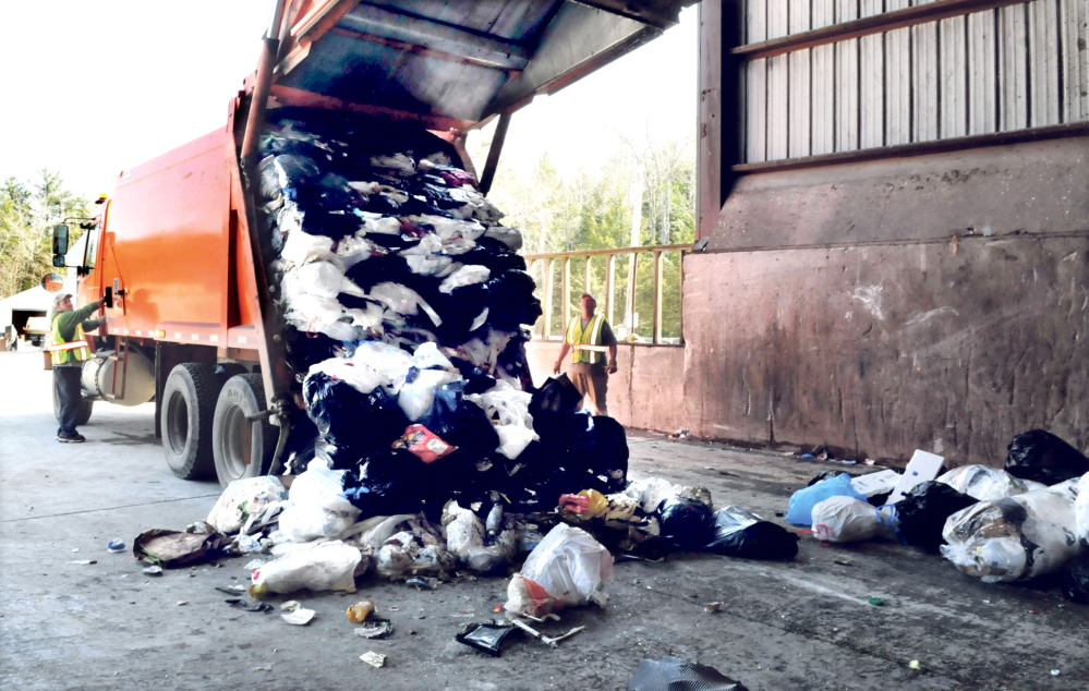 Waterville Public Works employees watch as a city garbage truck drops a load off at the Oakland transfer station in 2014. Trash from the transfer station is taken to the Penobscot Energy Recovery Co. in Orrington, but when communities' contracts with PERC end in 2018, Waterville plans to bring its garbage to a landfill in Norridgewock while Oakland has signed on to a new biofuel plan proposed for Hampden.