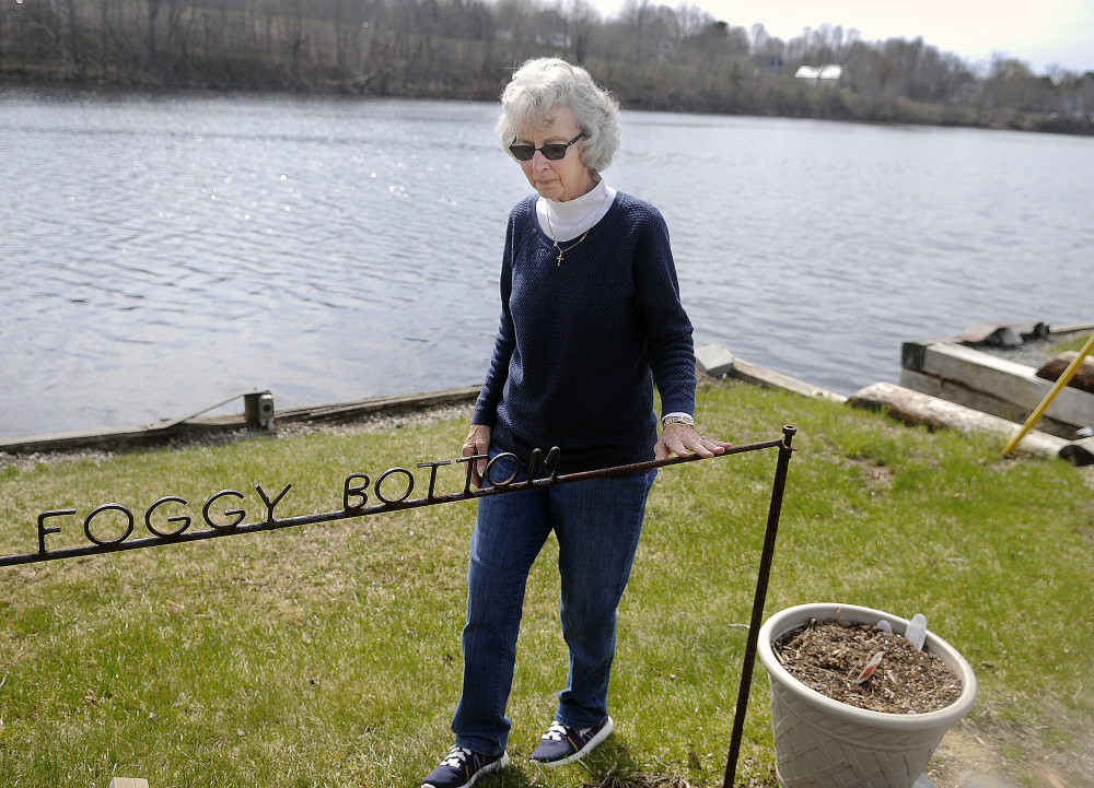 Sandra Alexander walks by the dock at Foggy Bottom Marine in Farmingdale on Sunday. She plans to continue operating the business on the Kennebec River several months after the death of her husband, Dan Alexander.
