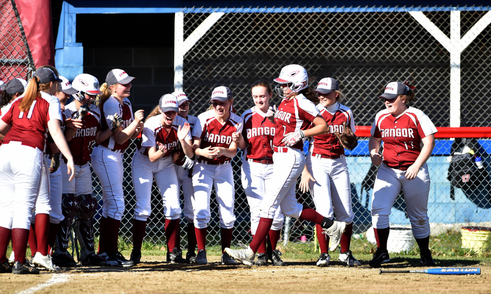 Bangor's Emily Gilmore (7) crosses the plate in front of eagerly-awaiting teammates after she belted a home run in the sixth inning Friday against Messalonskee.