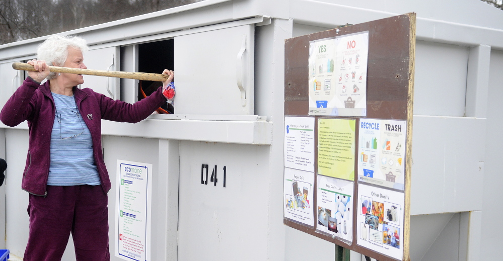 Augusta Public Works Director Lesley Jones tamps down items in the recycling station at Augusta Public Works to make way for other deposits in this April 2, 2015 file photo.
