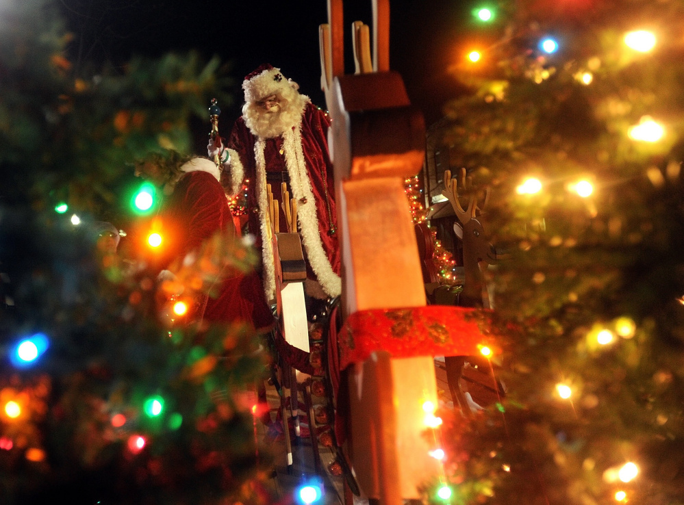 Santa Claus stands on top of his float in November 2014 at Kringleville at Castonguay Square in downtown Waterville during the Parade of Lights. The Waterville City Council is discussing whether to cut funding for Waterville Main Street, which is a sponsor of the Parade of Lights and other city events.