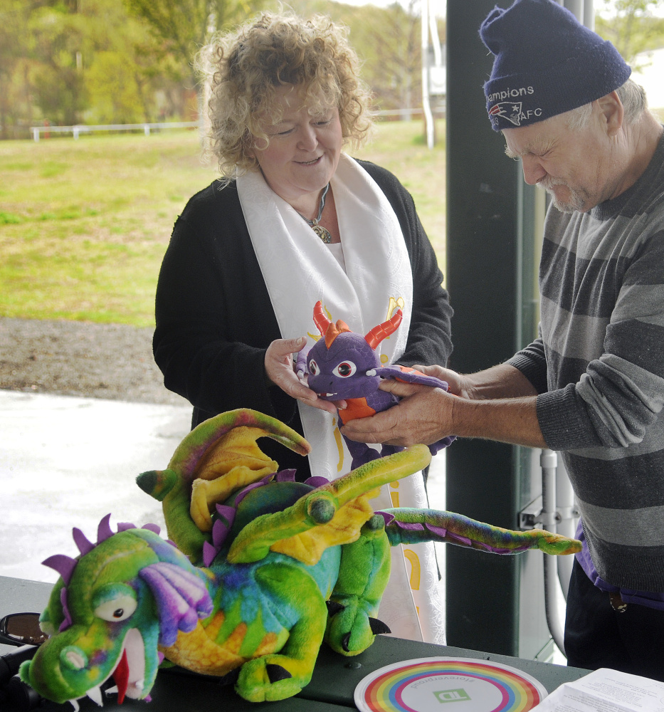 Rev. Carrie Johnsen blesses stuffed dragons belonging to George Stanley, of Greene, during a Unitarian Universalist Community Church service in Augusta Sunday.