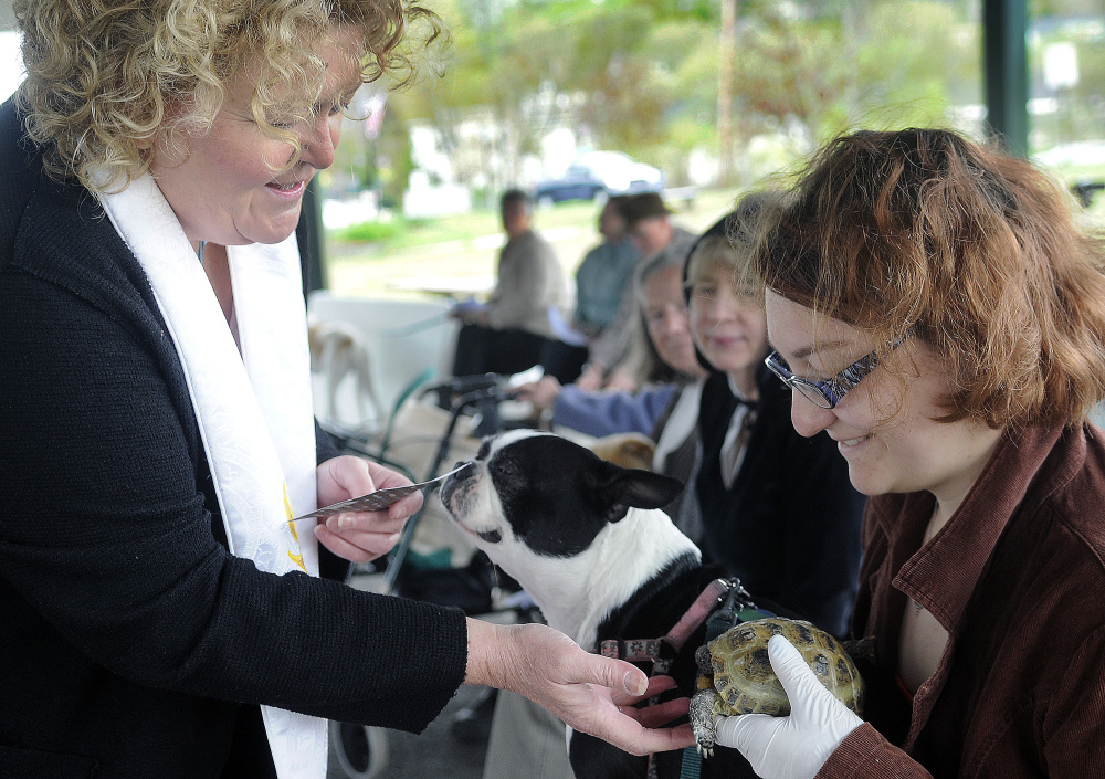 Rev. Carrie Johnsen blesses a dog, Flora, and tortoise, Gigi, belonging to Emma Chapin, of Winthrop, during a Unitarian Universalist Community Church service in Augusta Sunday.