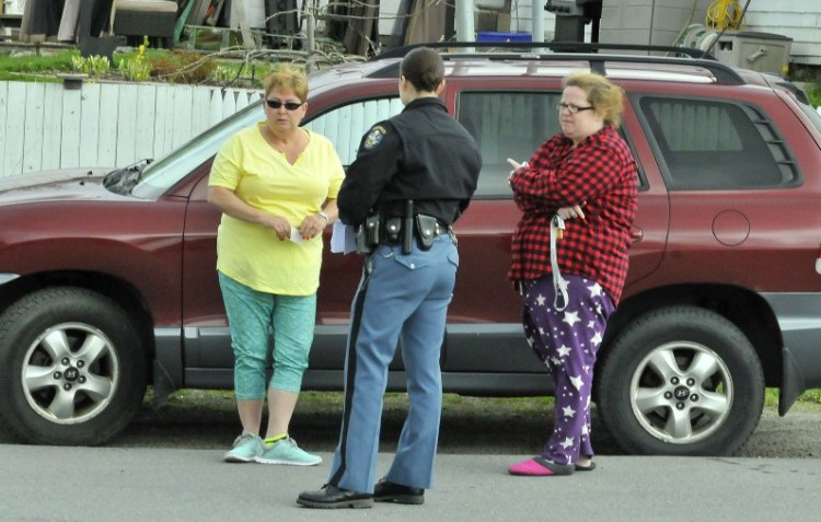 Rebecca Smith, left, of St. Albans, is interviewed by Trooper Jillian Monahan beside her car, where a masked man stole her purse Tuesday in the parking lot of the St. Albans Mini Mart. At right is Smith's friend Kelly Anderson.
