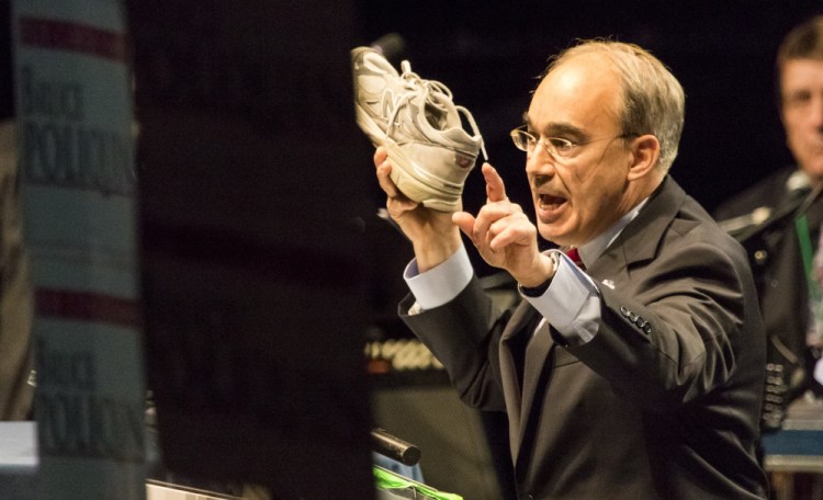 U.S. Rep. Bruce Poliquin holds a New Balance sneaker last month while addressing the state Republican convention in Bangor. Poliquin's language forcing the Department of Defense to buy U.S.-made athletic shoes was included in the National Defense Authorization Act for fiscal year 2017, the department's budget. It passed late Wednesday in the House.