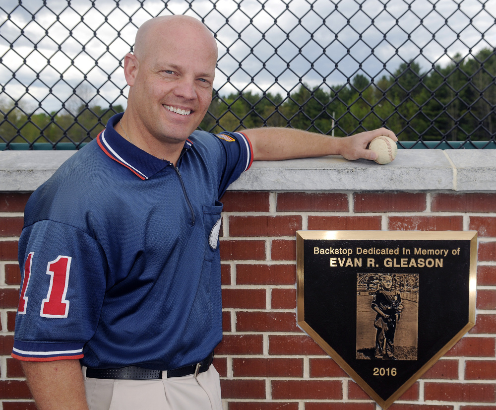 Keith Gleason stands next to the plaque in memory of his father, umpire Evan Gleason, beneath the new backstop at McGuire Field on Thursday in Augusta.