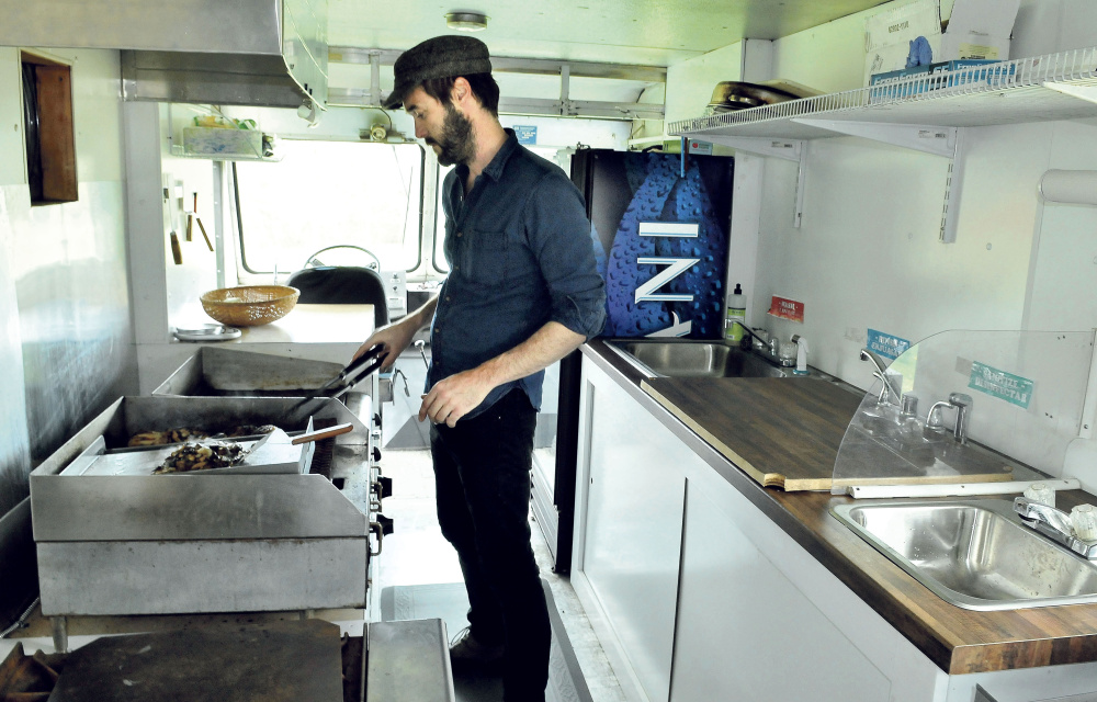 Garnet Keim cooks chicken and mushrooms in his food truck, El Toro, on Tuesday in Weld. The Weld native and his wife, Anne Holloway, moved back to the family farm five years ago, The couple's food truck is expected to debut this weekend.
