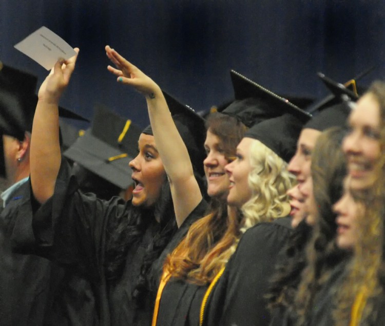 Graduates wave to audience members Saturday at start the of the Kennebec Valley Community College graduation at the Augusta Civic Center.