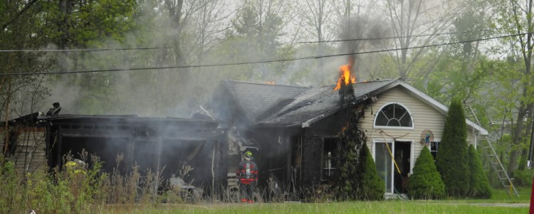 Firefighters from several departments work to put out a house fire Saturday on Pushard Lane in Gardiner.