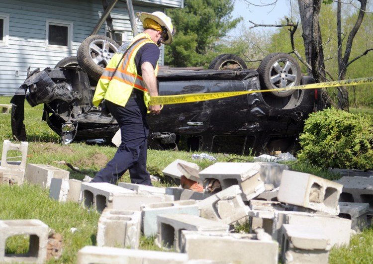 Augusta Fire Department Battalion Chief Steve Leach tapes around a wellhead that was struck Monday by a vehicle on Route 3 in Augusta.