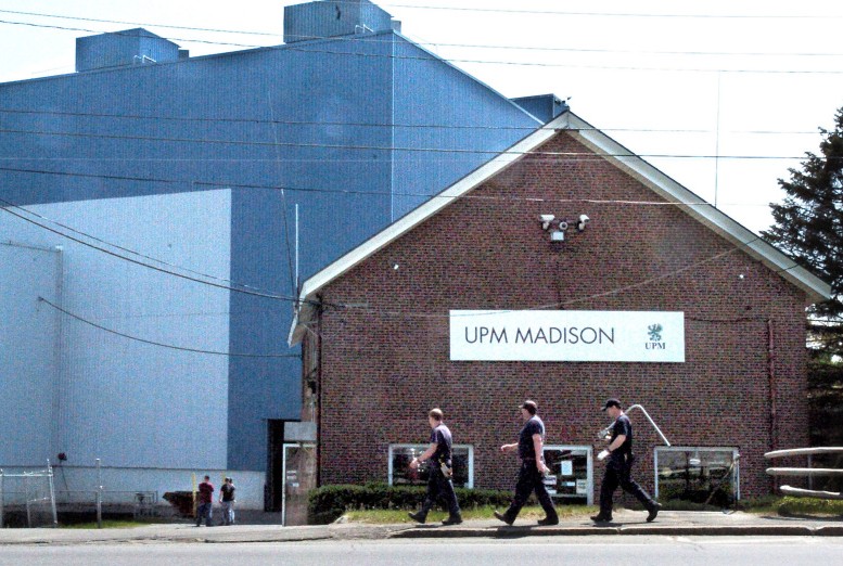 Mill workers carry tools into the Madison Paper Industries mill in Madison on Monday. The mill ended production last Saturday and will close.