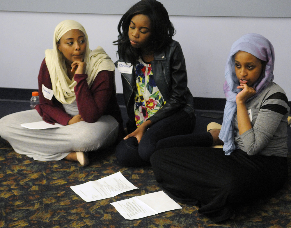 Lewiston High School students Iman Abdalla, left, Divine Selengbe and Zakiyah Sheikh moderate a discussion Monday with other civil rights team members about white privilege and stereotypes during a conference in Augusta.