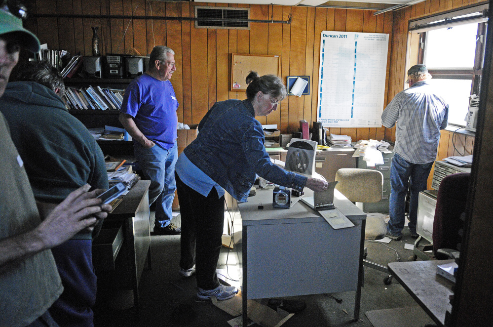 Carole Quackenbush, center, looks around the upstairs office during the preview for an informal auction last week at the former T.W. Dick facility in Gardiner. The facility will be cleaned up using federal funds.