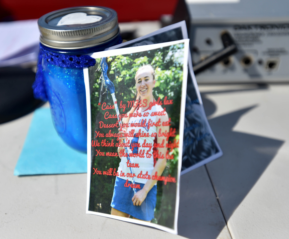 A picture of Cassidy Charette is tied to jar of sand representing dreams at Thomas College in Waterville on Thursday.