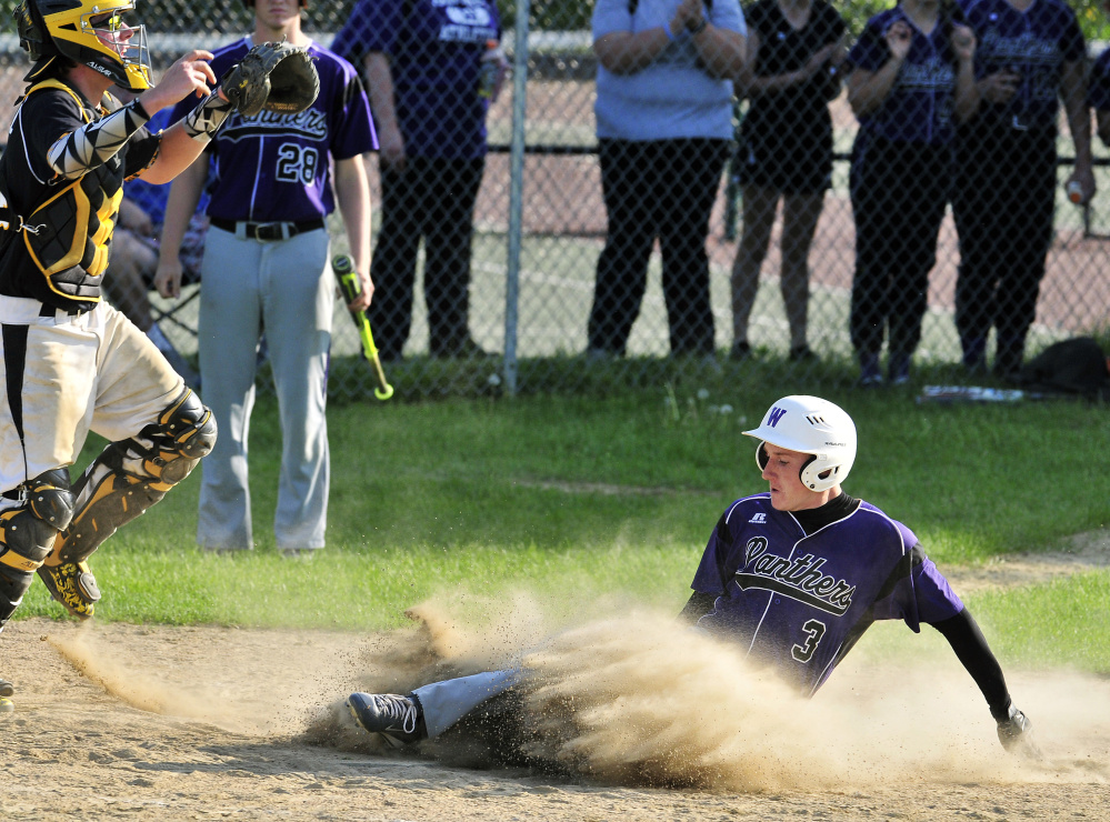 Maranacook catcher Mark Buzzell waits for the throw as Waterville runner Justin Wentworth scores to give his team a 3-1 lead in the seventh inning Friday.