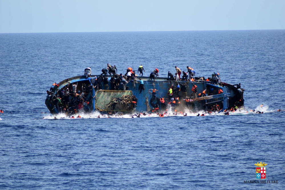 People try to jump in the water right before their boat overturns off the Libyan coast on May 25. Over 700 migrants are feared dead in three Mediterranean Sea shipwrecks south of Italy in the last few days as they tried desperately to reach Europe in unseaworthy smuggling boats, the U.N. refugee agency said Sunday.
