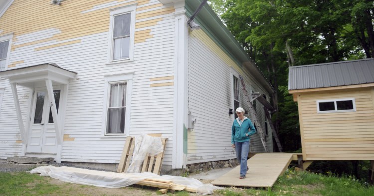 Marianne Archard walks down the new ramp at the Vienna Union Hall on Sunday. Renovations to the public performance space are underway, including a new outhouse, at right.