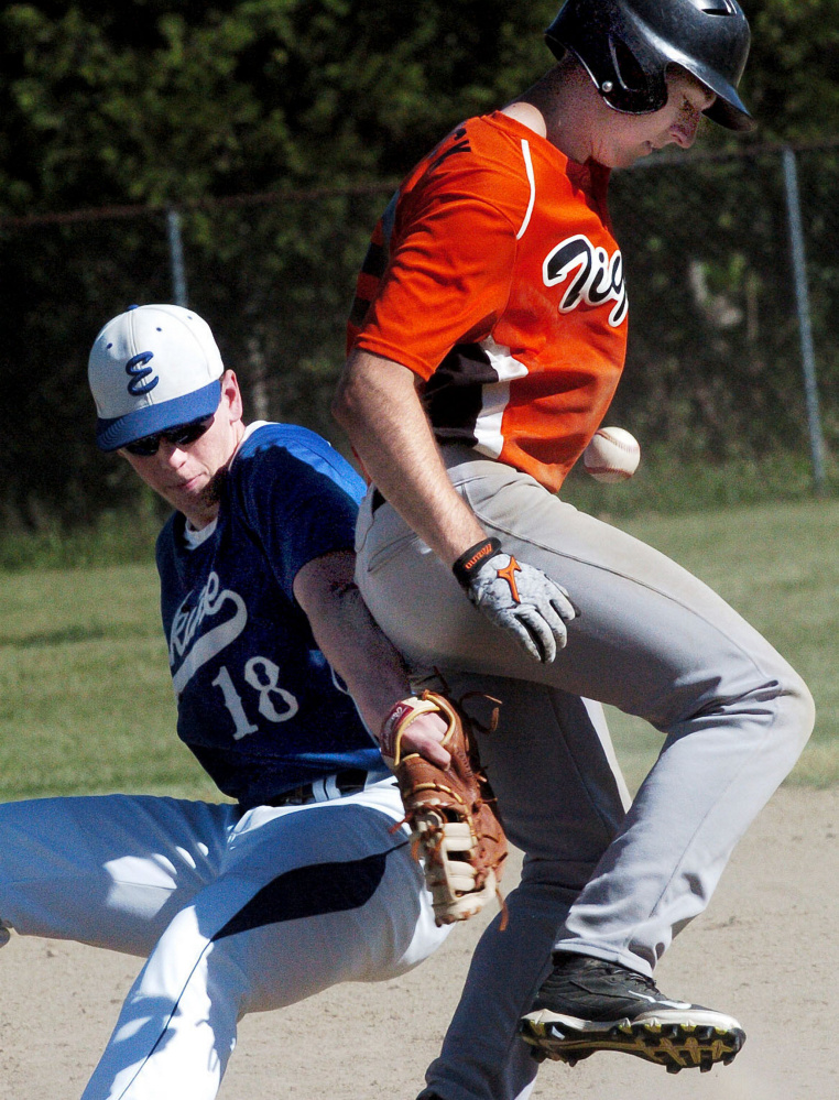 Gardiner runner Logan Peacock makes it back to first base as Erskine's Caleb Barden loses the ball during a Kennebec Valley Conference Class B game Tuesday in Gardiner.
