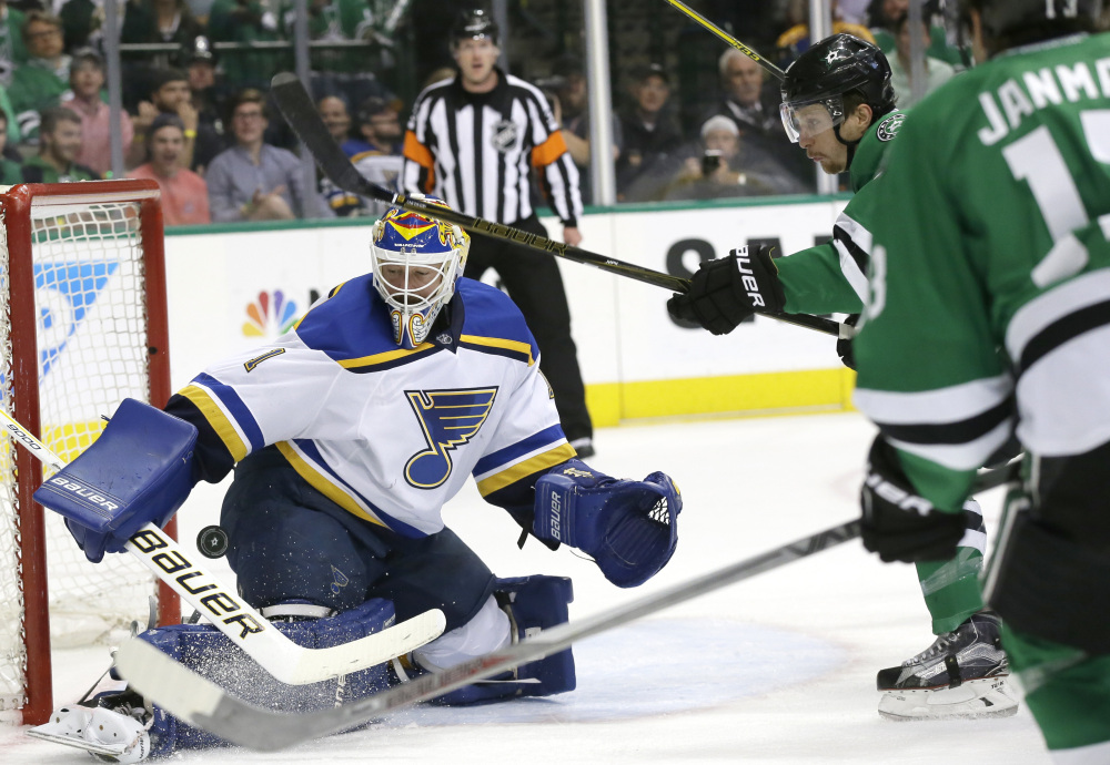 Blues goalie Brian Elliott defends the goal against Dallas left wing Antoine Roussel, 21, and center Mattias Janmark in the first period of Game 5 of the Western Conference semifinals Saturday in Dallas.