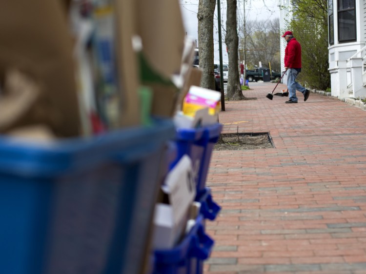 Cliff Bernard sweeps up litter on Bramhall Street last week. Bernard says he is subcontracted by Maine Medical Center to keep surrounding streets clean, a job made challenging on trash and recycling day. Derek Davis / Staff Photographer