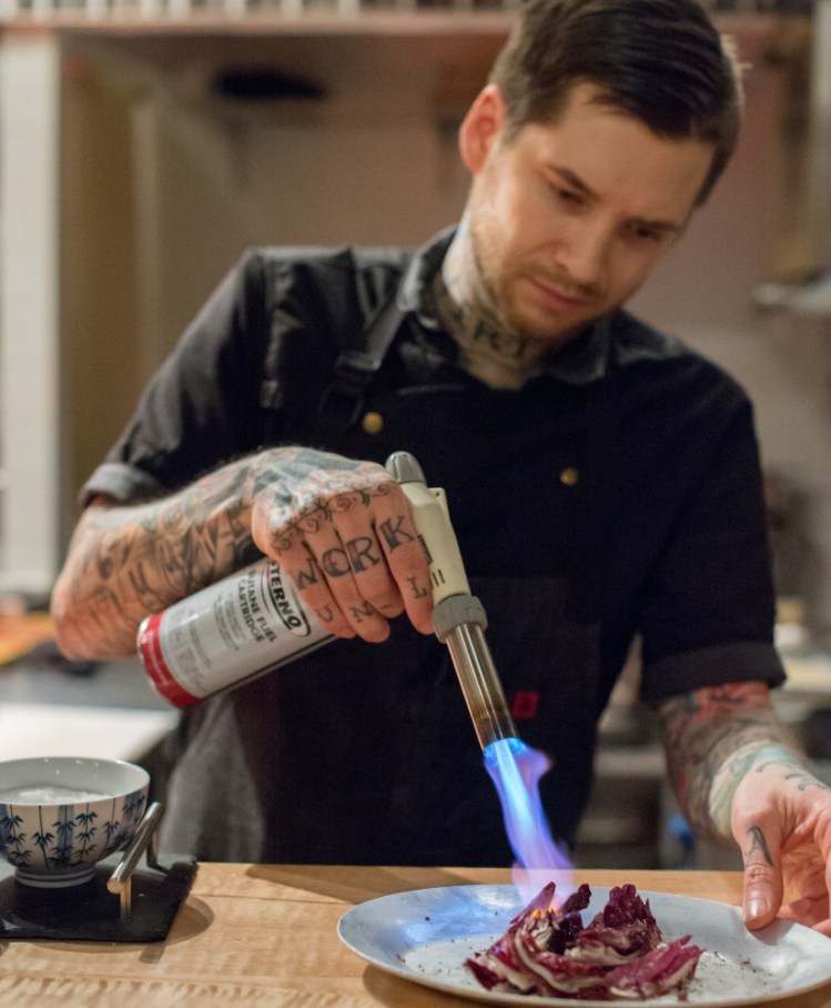 Rocky Hunter, vegetarian chef de cuisine at David's Opus Ten, uses a torch to char radicchio.  Photo by Jordan Moody for Brea McDonald Photography