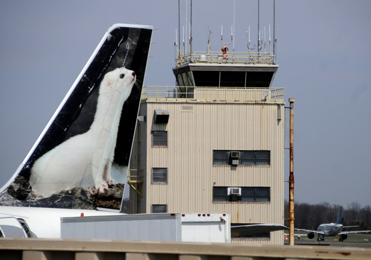 In this April 8, 2013 file photo, the painted tail appears on a Frontier Airlines aircraft parked at a gate at Trenton-Mercer Airport in Ewing, N.J.