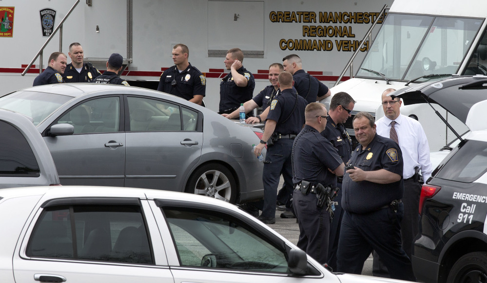 Police converge at a command post Friday in Manchester, N.H., after two Manchester police officers were shot overnight.