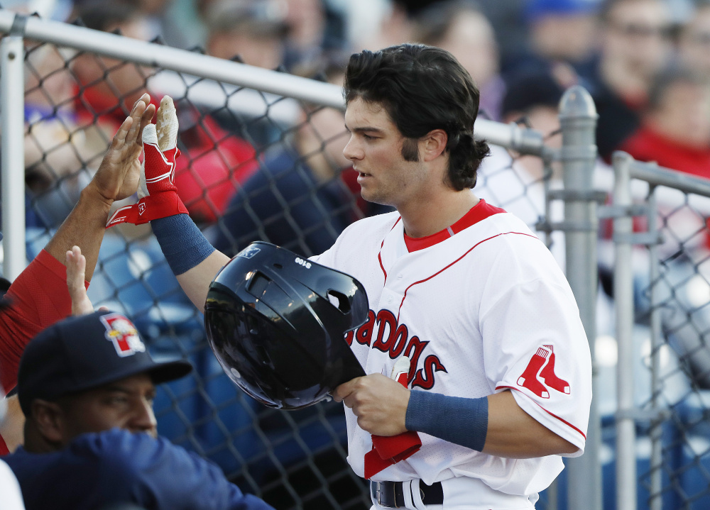 Andrew Benintendi is congratulated after scoring a run during the fifth inning Tuesday. Benintendi had 2 RBI in the Sea Dogs win.    Joel Page/Staff Photographer