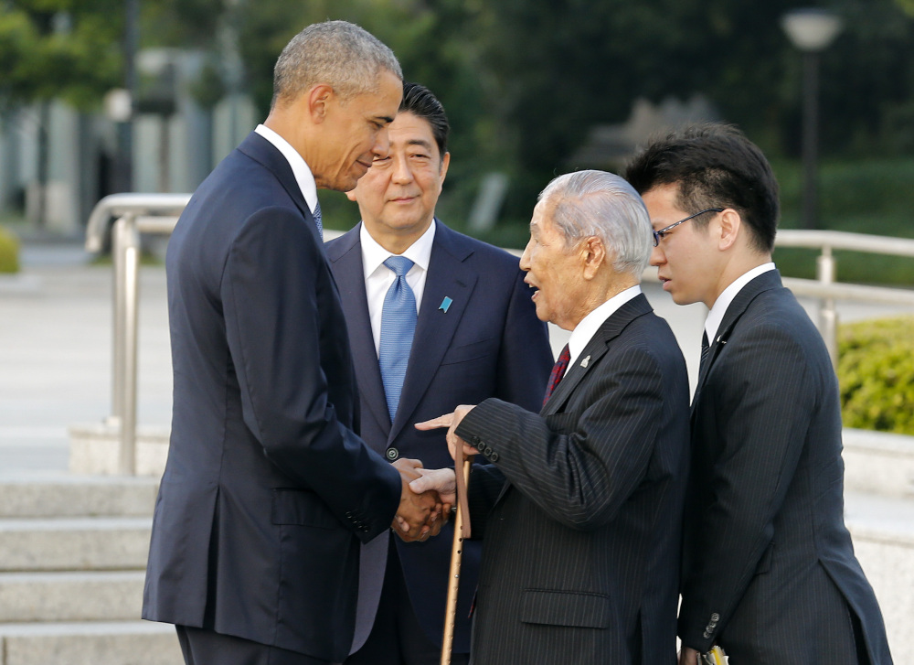 President Obama, left, shakes hands and chats with Sunao Tsuboi, second right, a survivor of the 1945 atomic bombing and chairman of the Hiroshima Prefectural Confederation of A-bomb Sufferers Organization, as Japanese Prime Minister Shinzo Abe watches them during his visit to Hiroshima Peace Memorial Park in Hiroshima, western Japan, Friday.