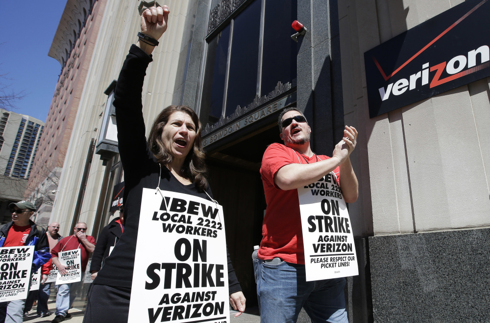 Verizon workers picket outside one of the company's facilities in Boston in April. Striking Verizon employees may be back to work next week after the company and its unions reached an agreement in principle Friday for a four-year contract.