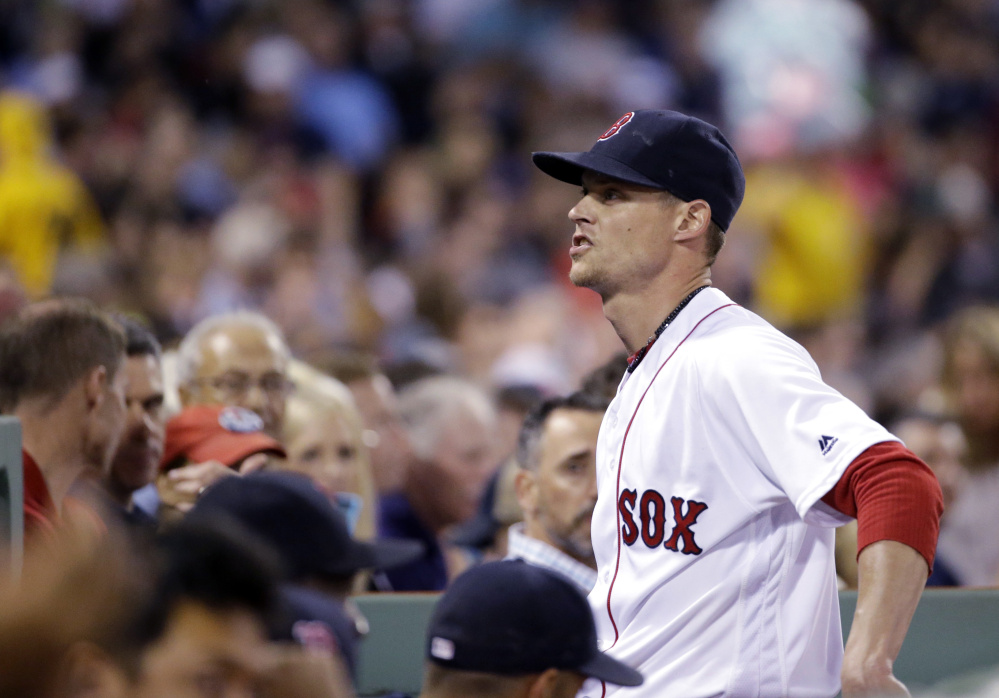 Boston Red Sox pitcher Clay Buchholz reacts to fans as he walks into the Boston dugout after the fifth inning of Thursday's game at Fenway Park. (AP Photo/Elise Amendola)