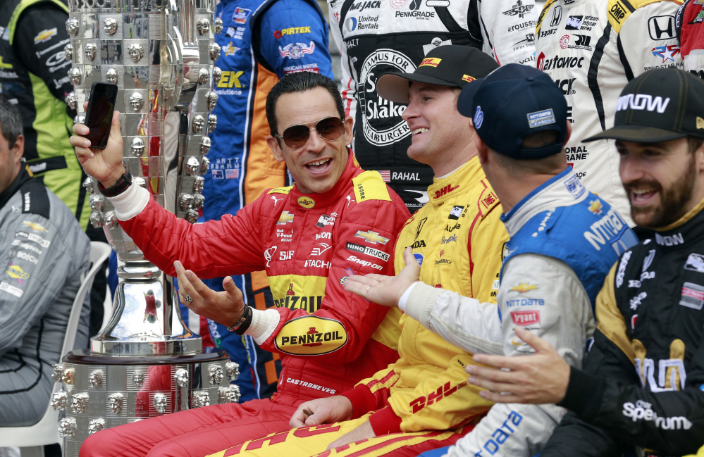 Helio Castroneves, left, jokes with Ryan Hunter-Reay, center, and Tony Kanaan while a photo of the starting field is taken Friday before the final practice session for the Indianapolis 500 at Indianapolis Motor Speedway.