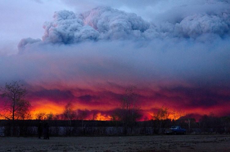 A wildfire moves toward the town of Anzac from Fort McMurray, Alberta., on Wednesday. Unseasonably hot temperatures combined with dry conditions have transformed the boreal forest in much of Alberta into a tinder box.  