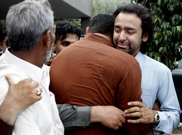 In this May 2013 photo, people comfort Musa Gilani, right, the brother of Ali Haider Gilani who was kidnapped in Multan, Pakistan. Ali Haider Gilani was rescued Tuesday after three years of captivity in a joint raid by U.S. and Afghan forces. The Associated Press