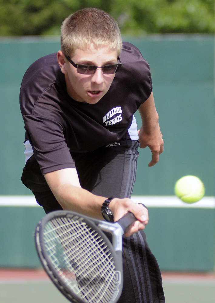 Hall-Dale High School's Isaac Lawrence returns a serve during a doubles match against Winthrop High School on Thursday in Farmingdale.