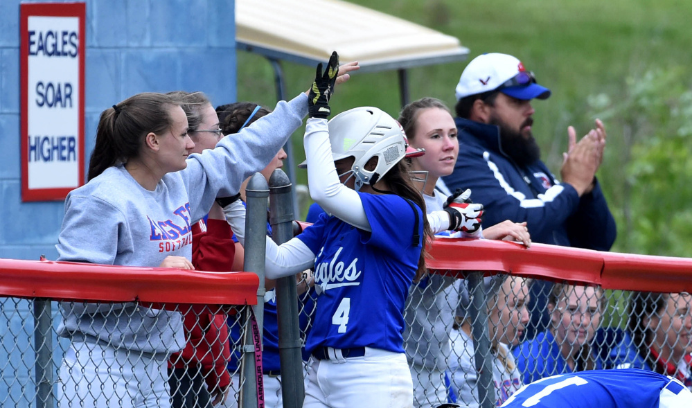 Messalonskee's Kelsey Dillon is contragulated by teammates after she scored in the first inning of the Kennebec Valley Athletic Conference Class A championship game Friday against Oxford Hills.