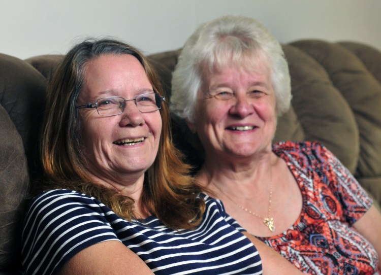 Sisters Jane McDougal, left, and Betty Bickford pose for a portrait Thursday in Sidney. They were separated at birth when McDougal was put up for adoption. McDougal found Bickford about two years ago.