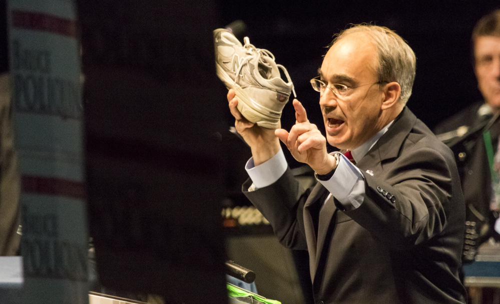 U.S. Rep. Bruce Poliquin, R-2nd District, a keynote speaker during the second day of the Maine Republican Party's state convention at the Cross Insurance Arena in Bangor, holds aloft a New Balance sneaker while calling for changes to the Berry amendment that would favor U.S. made sneakers for military personnel.