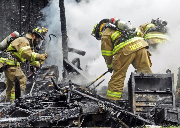 Augusta firefighters dig to find any remaining hot spots Tuesday after putting out a fire in a shed on Albee Road in Augusta. The shed was destroyed, but the fire was stopped before it destroyed an adjacent house.
