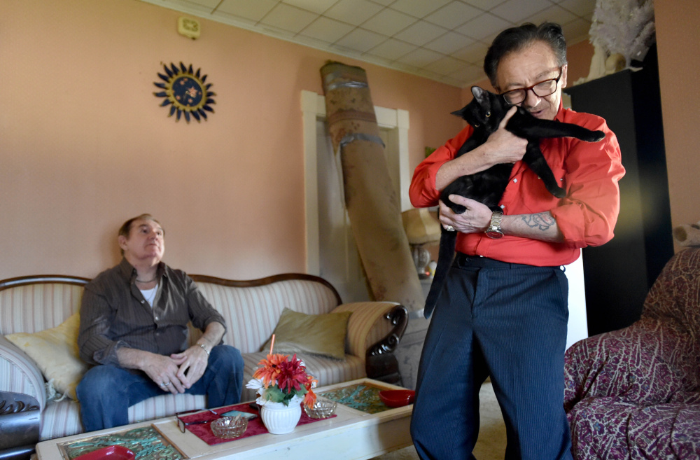 Aldo Baldie cuddles with his cats, Mother Mary and Saint Joseph, at his new apartment with his husband, Ron Pelletier, on the couch in the background in April. The couple lost seven pets when their Canaan home was burned in an arson in September. Matthew Short, of Canaan, pleaded guilty Tuesday.