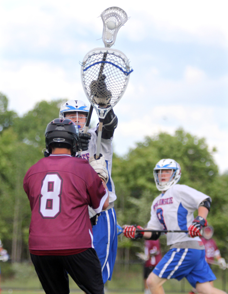 Messalonskee High School's Dylan Jones reaches up to intercept a pass from Edward Little goalie Brandon Asselin before whipping a pass to Connor Smith for a score in the first half of Class A North quarterfinal playoff game at Thomas College in Waterville on Wednesday.