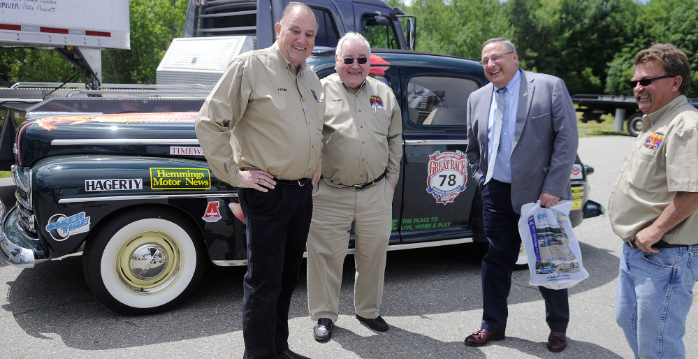 Race team members Frank Crooker, left, Peter Prescott and John Myrick, right, laugh with Gov. Paul LePage on Thursday at the team's garage in Gardiner. The team is participating in the 2016 Hemmings Motor News Great Race across the western United States with a car provided by Prescott.