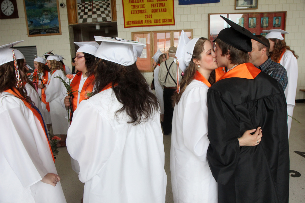 Breanna Scoville steals a kiss from her boyfriend, Joshua Carey, prior to the start of commencement ceremonies at Skowhegan Area High School on Sunday. Scoville plans to attend the University of Maine at Orono while Carey plans to attend the University of Maine at Farmington.